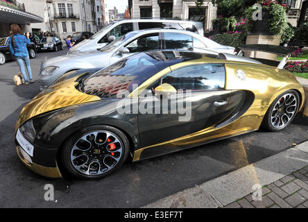 Les passants s'arrêter pour vérifier deux voitures flashy garé à l'extérieur de la face de l'Hôtel Dorchester. Une Lamborghini Aventador violet et jaune et or Bugatti Veyron. En vedette : Bugatti Veyron Où : London, Royaume-Uni Quand : 20 Oct 2013 Banque D'Images