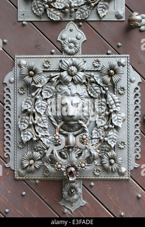 Tête de lion en bronze knocker sur une porte en bois Banque D'Images