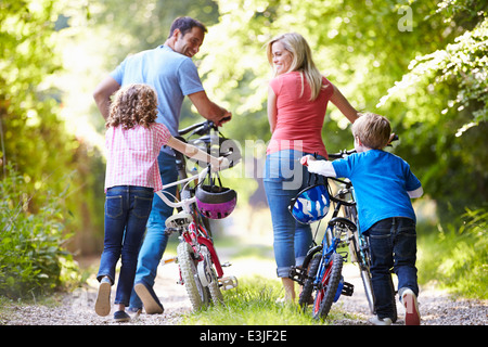 Poussant la famille de vélos le long de la voie de Pays Banque D'Images