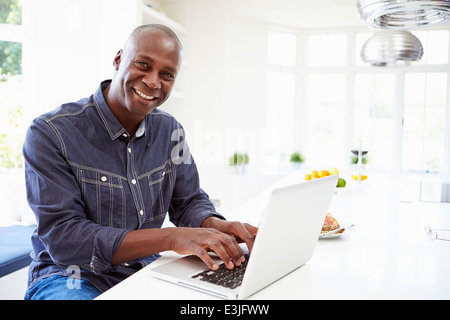 African American Man Using Laptop At Home Banque D'Images