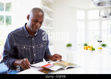 African American Man reading Magazine à la maison Banque D'Images