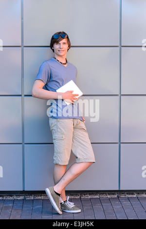 Confiant college student boy with tablet pleine longueur permanent Banque D'Images