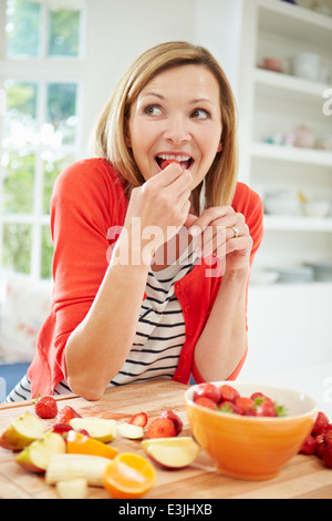 Femme de la préparation de la salade de fruits dans la cuisine Banque D'Images