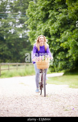 Teenage Girl Riding Bike le long chemin de campagne Banque D'Images