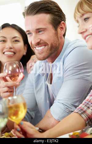 Groupe d'amis assis autour de la Table de dîner de travail Banque D'Images