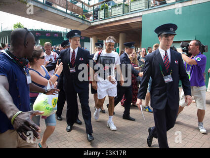 Wimbledon, Londres, Royaume-Uni, 24 juin, 2014. Photo montre Roger Federer (SUI) sur la deuxième journée du championnat de tennis de Wimbledon 2014 être escorté par la sécurité par les spectateurs après le préchauffage sur le Court N°4 Crédit : Clickpics/Alamy Live News Banque D'Images