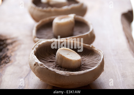 Trois champignons portobello rustique sur une planche à découper Banque D'Images