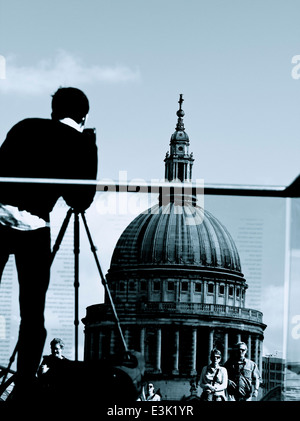 Touristes traversant le pont du Millénaire et l'homme de prendre photo sur trépied de St Paul's Cathedral Londres Angleterre Europe Banque D'Images