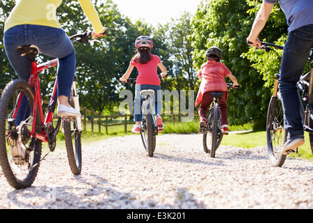 Vue arrière de la famille hispanique sur Balade en vélo dans la campagne environnante Banque D'Images