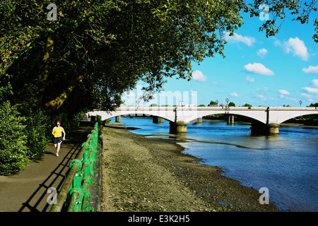 Woman running jogging sur le chemin de la Tamise près de grade II Putney Bridge Londres Angleterre Europe Banque D'Images