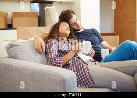 Fatigué Couple Relaxing On Sofa In New Home Banque D'Images