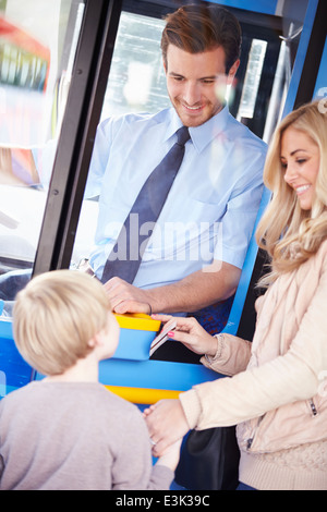 La mère et le fils de bus d'embarquement et l'aide Banque D'Images