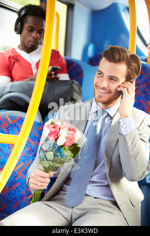 Cours à ce jour, l'homme sur le bus Holding Bunch of Flowers Banque D'Images