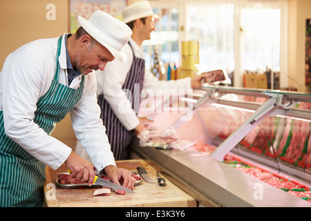 Deux bouchers préparer la viande en boutique Banque D'Images