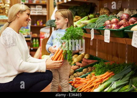 Mère et fille de choisir des légumes frais dans Farm Shop Banque D'Images