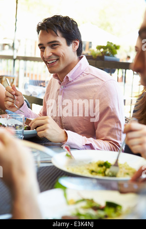 Man Enjoying repas au restaurant en plein air avec des amis Banque D'Images