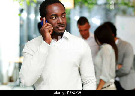 Beau portrait de l'Afrique sur le smartphone devant des collègues Banque D'Images