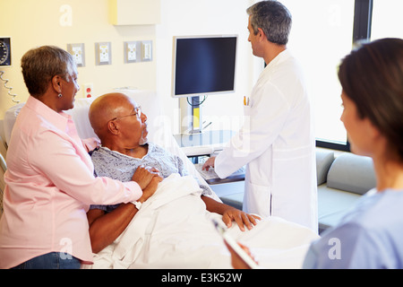 Rencontre avec l'équipe médicale Senior Couple in Hospital Room Banque D'Images