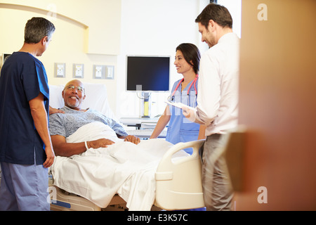 Rencontre avec l'équipe médicale Senior Man In Hospital Room Banque D'Images