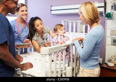 Mère et fille avec le personnel en service de pédiatrie de l'hôpital Banque D'Images