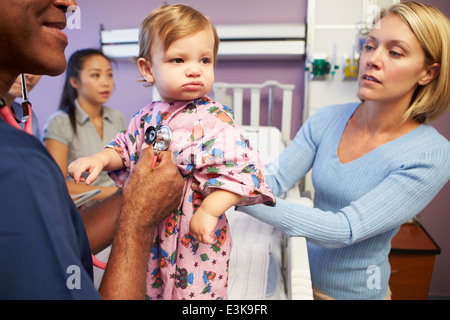 Mère et fille avec le personnel en service de pédiatrie de l'hôpital Banque D'Images