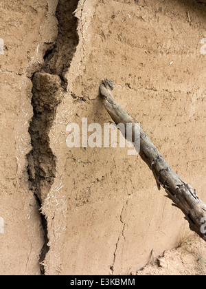 Une fissure et appuyé l'article de boue-brique mur d'être soutenu par un support en bois Banque D'Images