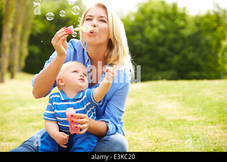 Mère Faire des bulles pour jeune garçon de jardin Banque D'Images