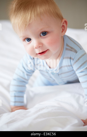 Les jeunes Baby Boy Playing In Bed Banque D'Images