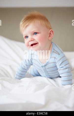 Les jeunes Baby Boy Playing In Bed Banque D'Images