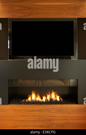 Dans le salon d'accueil moderne avec TV et cheminée Banque D'Images