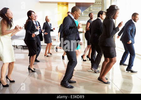 Hommes et de femmes d'affaires et la danse In Office Lobby Banque D'Images