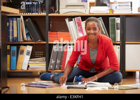 Bureau Businesswoman Sitting on Floor Reading Documents Banque D'Images