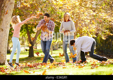 Jeter les feuilles d'automne de la famille dans l'air Banque D'Images