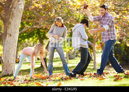 Jeter les feuilles d'automne de la famille dans l'air Banque D'Images