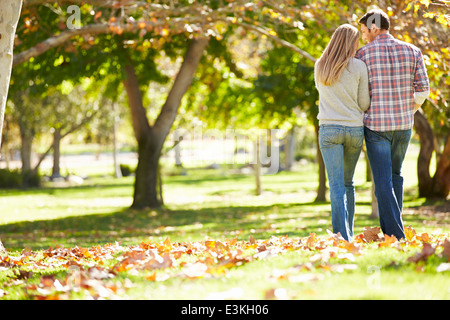 Vue arrière du couple romantique marche à travers bois d'automne Banque D'Images