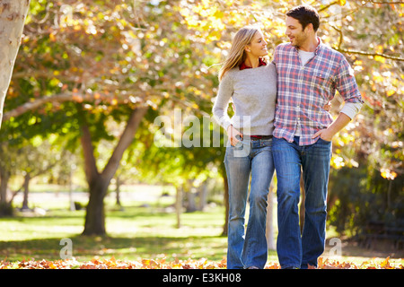 Romantic Couple marchant à travers bois d'automne Banque D'Images
