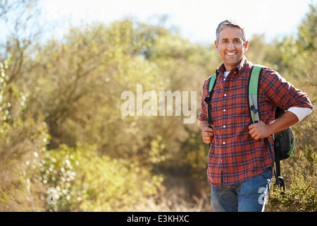 Portrait d'un homme portant un sac à dos de randonnée dans la campagne environnante Banque D'Images