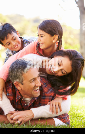 Family Lying On Grass In Countryside Banque D'Images