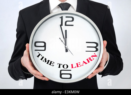 Businessman holding horloge avec le temps d'apprendre Banque D'Images