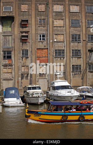 Contraste de ferry et bateaux modernes avec ruiné bâtiment abandonné sur la rivière Avon, Bristol en mai Banque D'Images