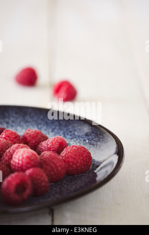 Framboises sur Plaque sur fond blanc Banque D'Images