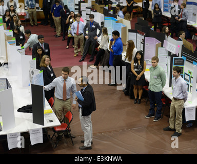 High school student explique son projet de recherche d'une foire scientifique juge, d'autres élèves de consulter sur le New Jersey Banque D'Images