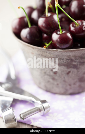 English Les cerises au bol en métal avec Cherry Stoner Banque D'Images