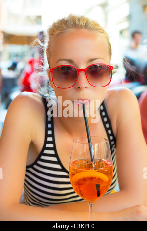 Femme avec cocktail au café de la rue. Banque D'Images