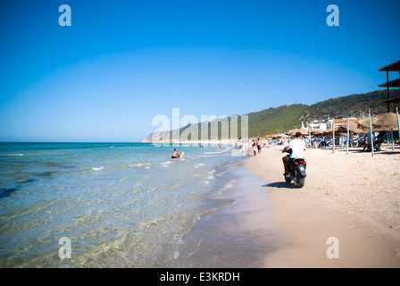 Homme conduisant une moto sur une plage en Tunisie Banque D'Images