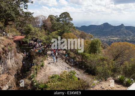 Les visiteurs qui entrent dans la pyramide d'el Tepozteco - Tepoztlán, Morelos, Mexique. Le village de Tepoztlán se trouve dans la vallée ci-dessous. Banque D'Images