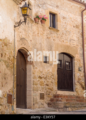Pals maison en pierre : pierre chaude avec des pots de géraniums. La chaleureuse façade en pierre d'une ancienne maison dans la petite ville de Pals Banque D'Images
