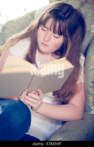 Photo de teenage girl (13-15) reading book Banque D'Images