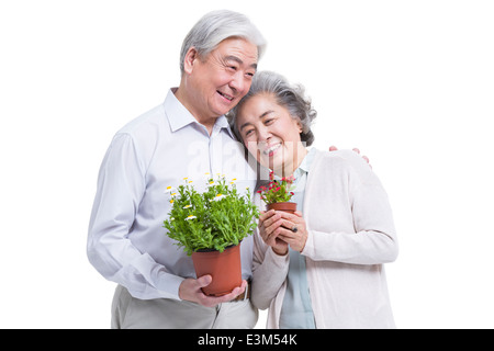 Happy senior couple with potted plants Banque D'Images