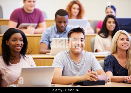 Les élèves à l'aide d'ordinateurs portables et tablettes numériques en conférence Banque D'Images
